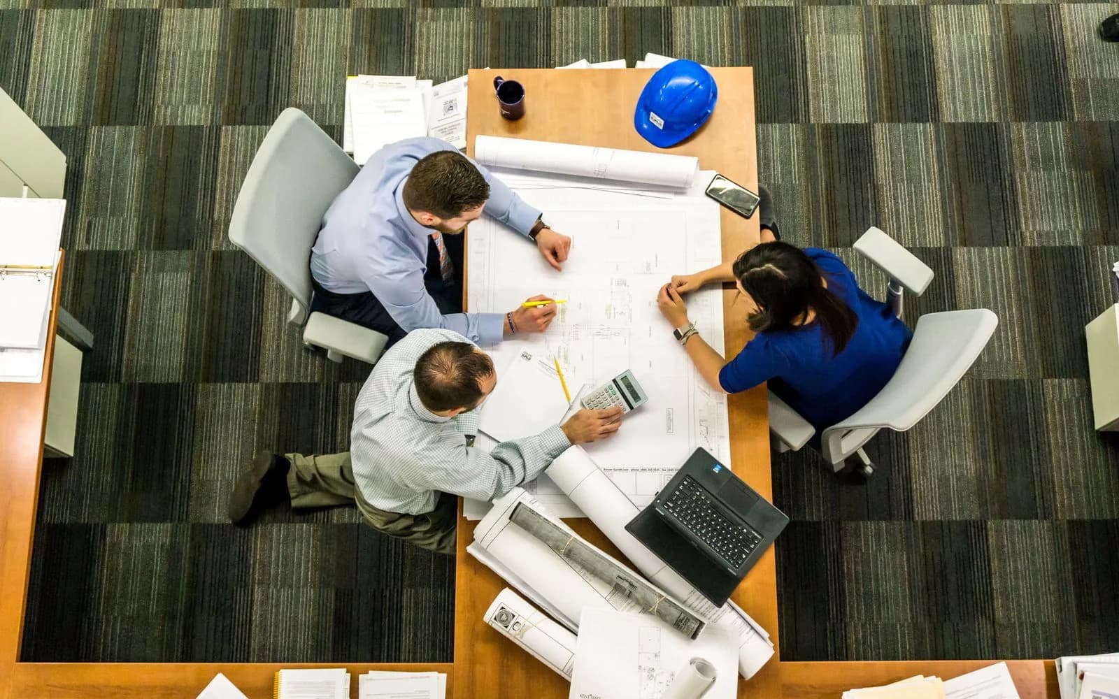 A team working together at a desk over project drawings